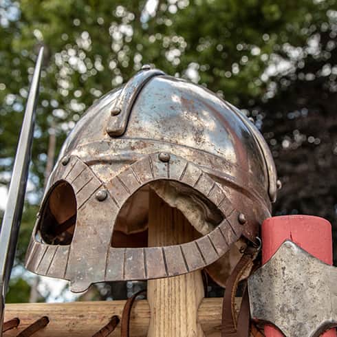 The image shows a replica Viking helmet made from steel that has extra eye protection. Based on a find from Gjermundbu Norway
