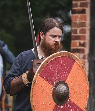 This image shows a warrior wielding an orange and red shield, denoting his house fyrdraca