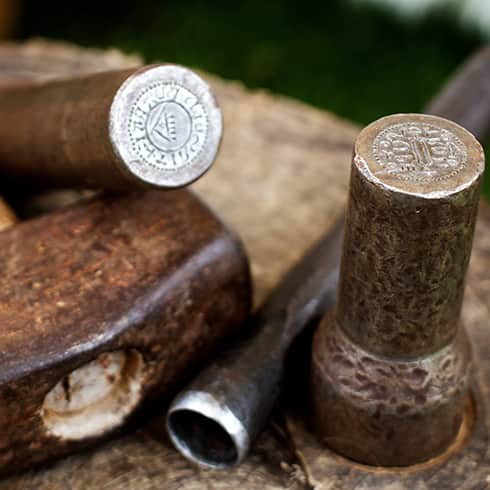 The image shows coin making dyes made from iron, with the coin designs etched into them.