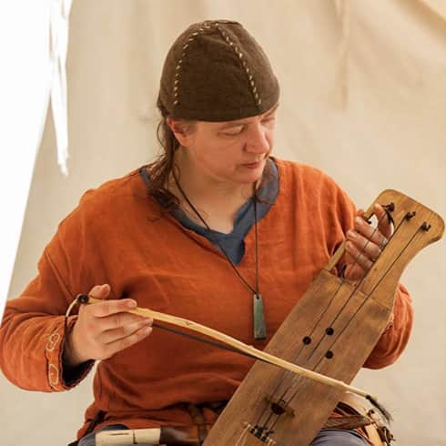 The image shows a musician playing a lyre.